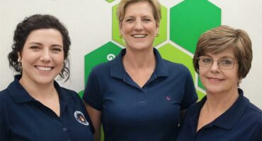three woman with a white and green background