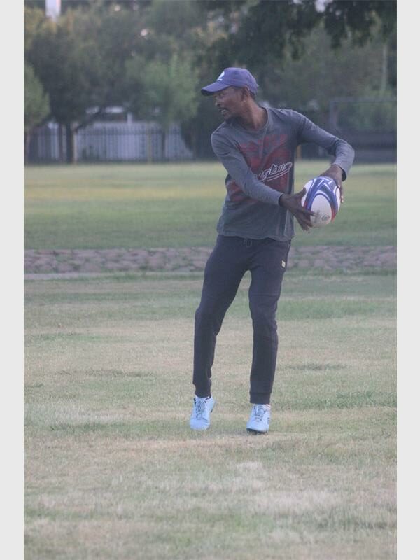 a man with a rugby ball is ready to pass it to another player