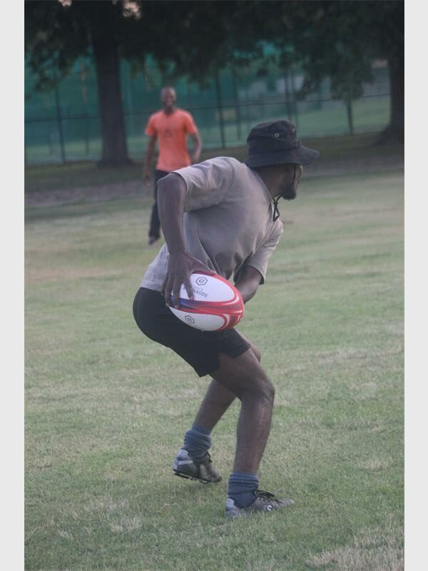 a man with a rugby ball is ready to pass it to another player
