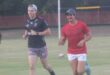 two young men jog on a rugby veld