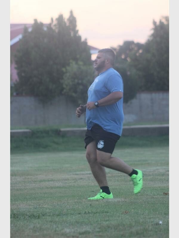 big man with blue tshirt and neon green tocks