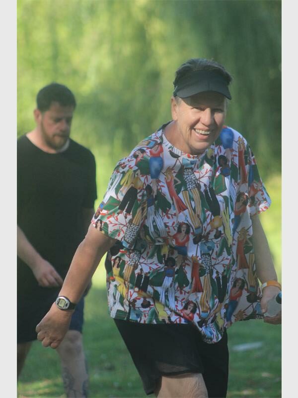 woman wears a colourful t-shirt and walks in the outdoors