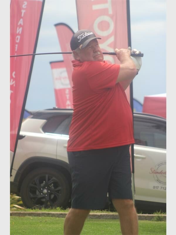 man with red shirt and moustache tees off