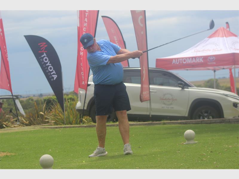 man in blue tees off
