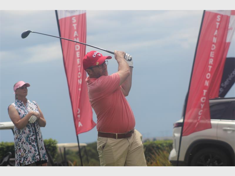 man with red shirt and cap tees off
