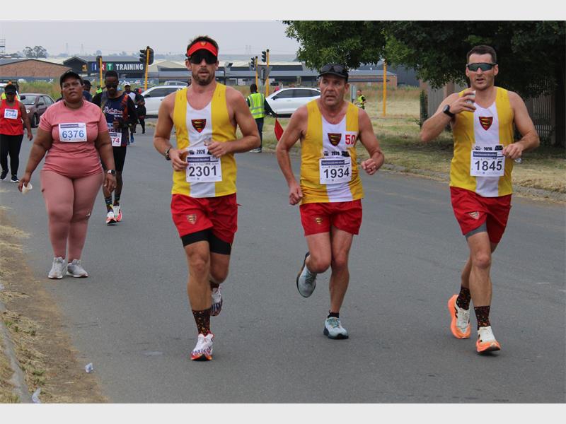 men dressed in yellow and red outfits run a marathon