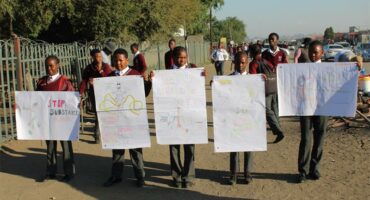 learners hold up posters against drugs