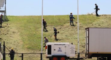 workers cut grass at the stadium