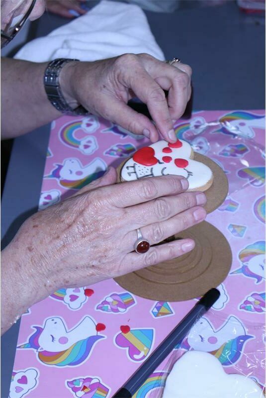 Two hands holding a heart-shaped cookie