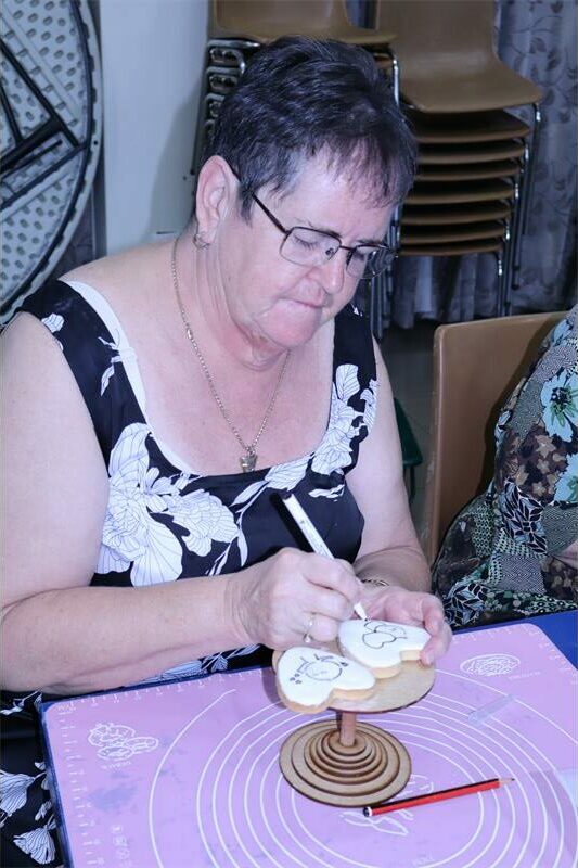 A woman traces an image onto a cookie