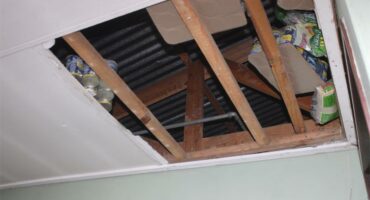 removed ceiling board with food stashed in the rafters