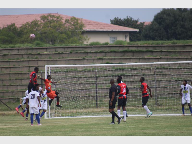 team in red plays soccer against team in white