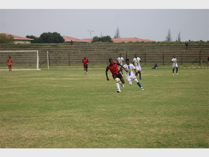 team in red plays soccer against team in white