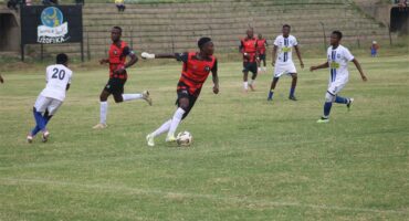 team in red plays soccer against team in white