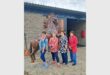 four women in front of a horse stable