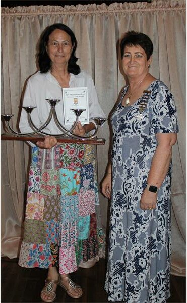two women with menora candle holder