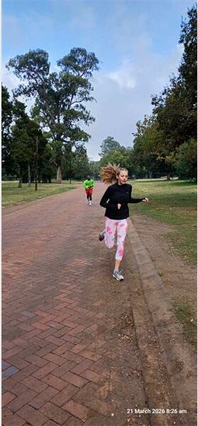 a girl runs on a gravel road in the park