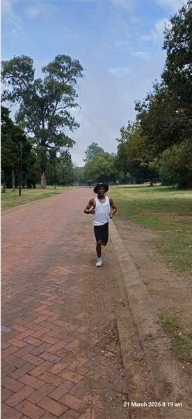 a boy runs on a gravel road in the park