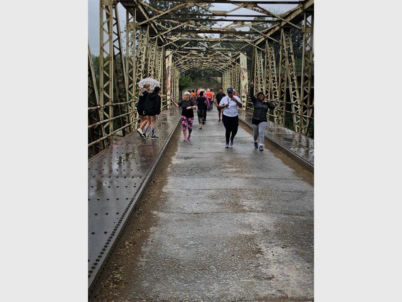 people walk over an old bridge