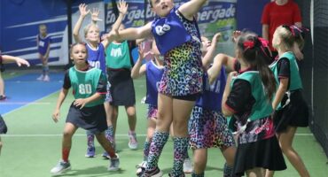 a girl humps in the air while playing netball