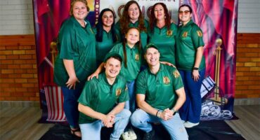 a group of people with green shirts and denim