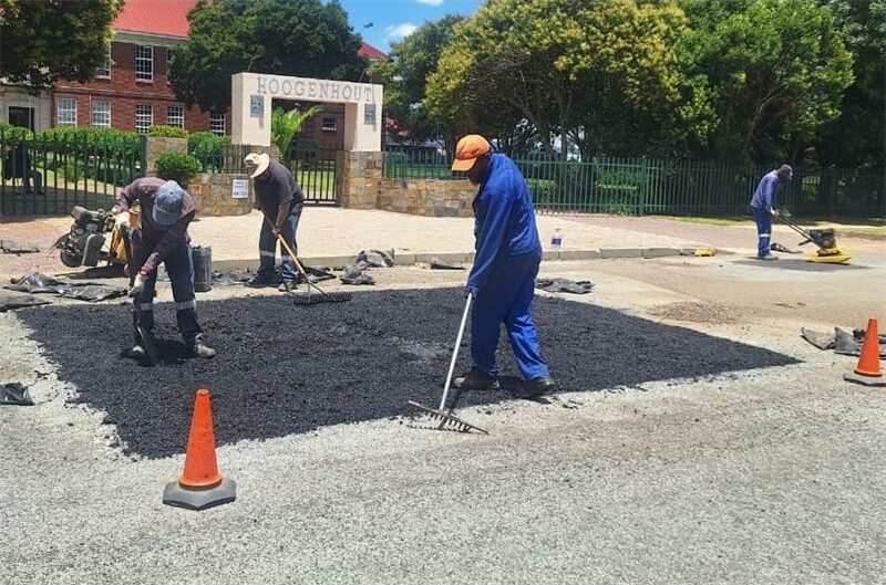 workers fill up a pothole