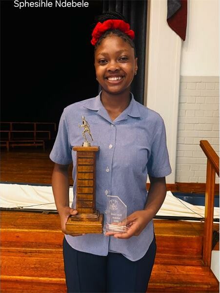 girl with a red ribbon in her hair and a school uniform holds up trophies