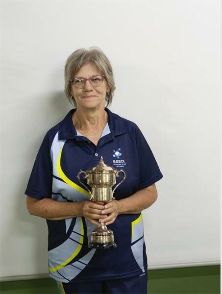 a woman in sport clothes holding a trophy