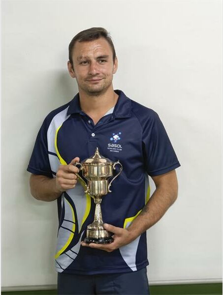 a young man in sport clothes with a trophy