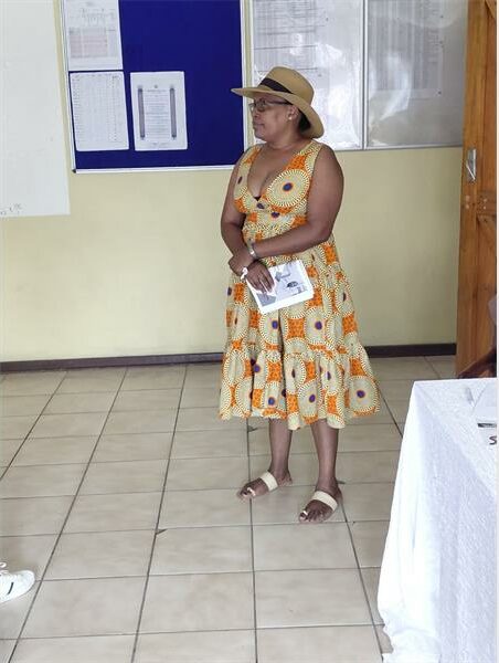 woman in a bright flower dress and hat