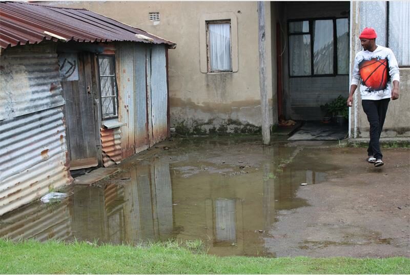 a man tries to avoid sewage flooding a yard