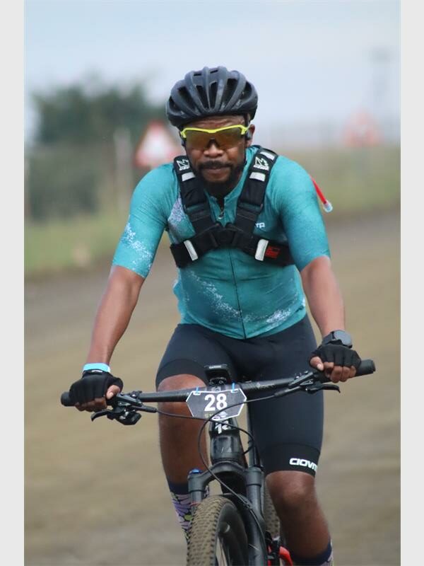 a cyclist with an aqua colour shirt and a back pack