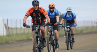 three cyclists on a dirt road