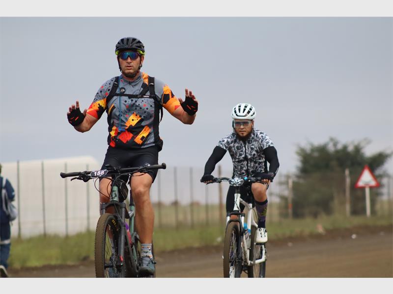 a cyclist peddles without holding on to the handlebar of his bicycle
