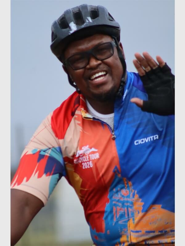 a cyclist smiles and waves