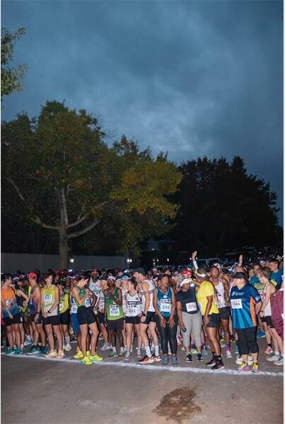 people at the start of a race on a tar road in the dark