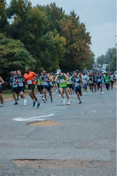 people running a race on a tar road in the dark