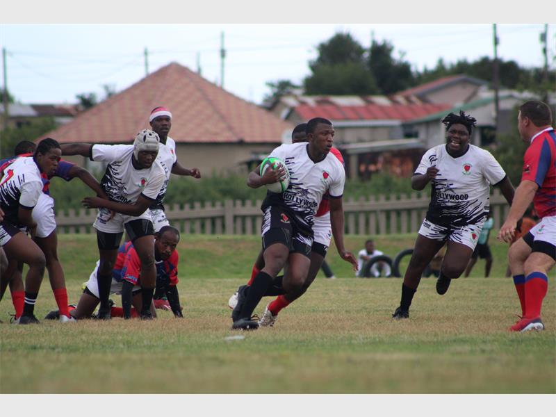 a player in white runs with the rugby ball