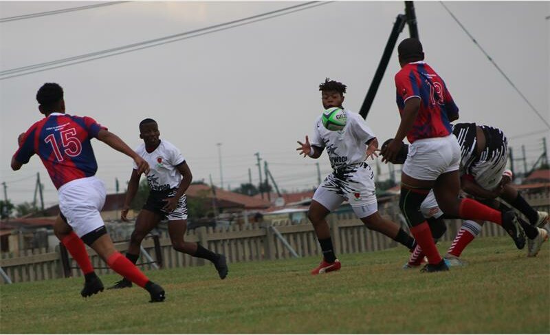 rugby player in white tries to catch the ball