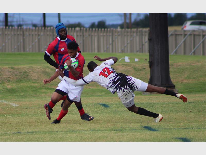 a player in white runs with the rugby ball