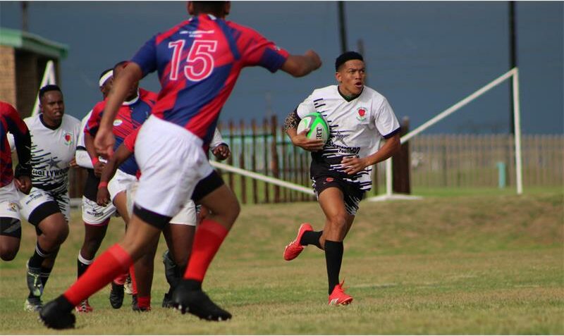 a player in white runs with the rugby ball