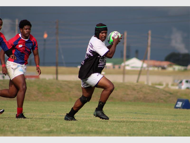 a player in white runs with the rugby ball