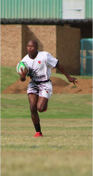 a player in white runs with the rugby ball