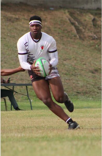 a player in white runs with the rugby ball