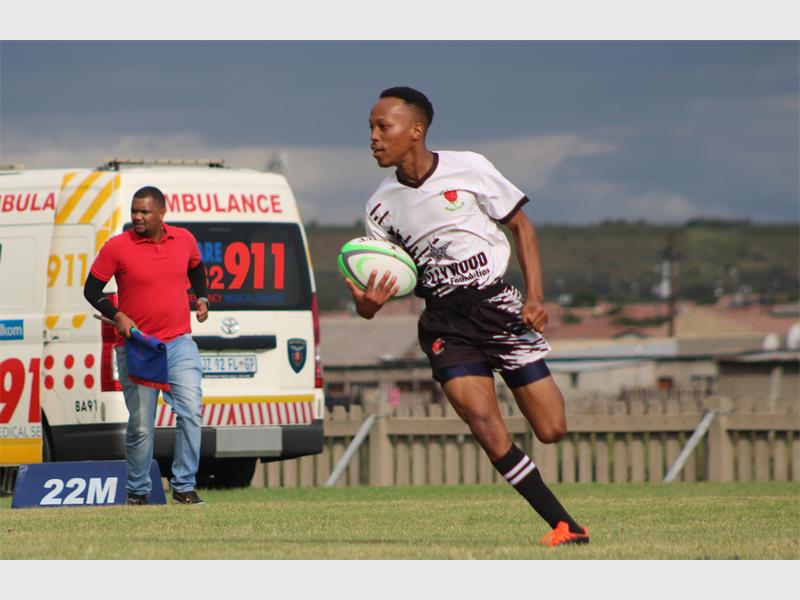 a player in white runs with the rugby ball