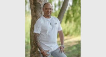 a man posing by a tree