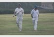 two cricket players walk off the pitch
