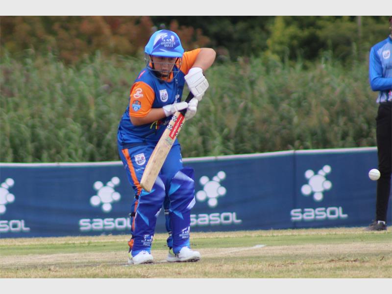 boy in orange and blue cricket clothes bats
