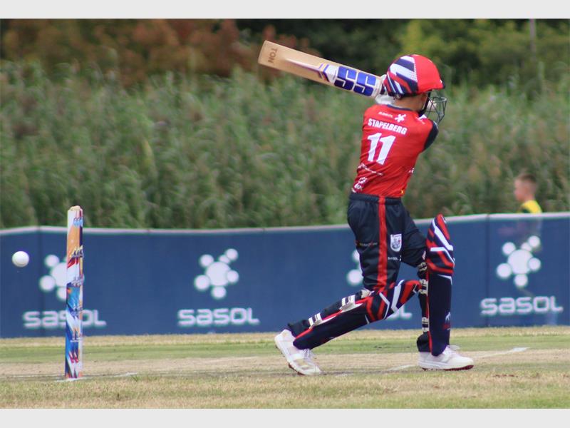 boy in red and black cricket clothes bowl