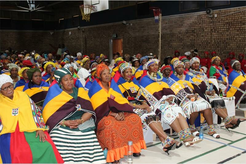 women with colourful blankets over their shoulders